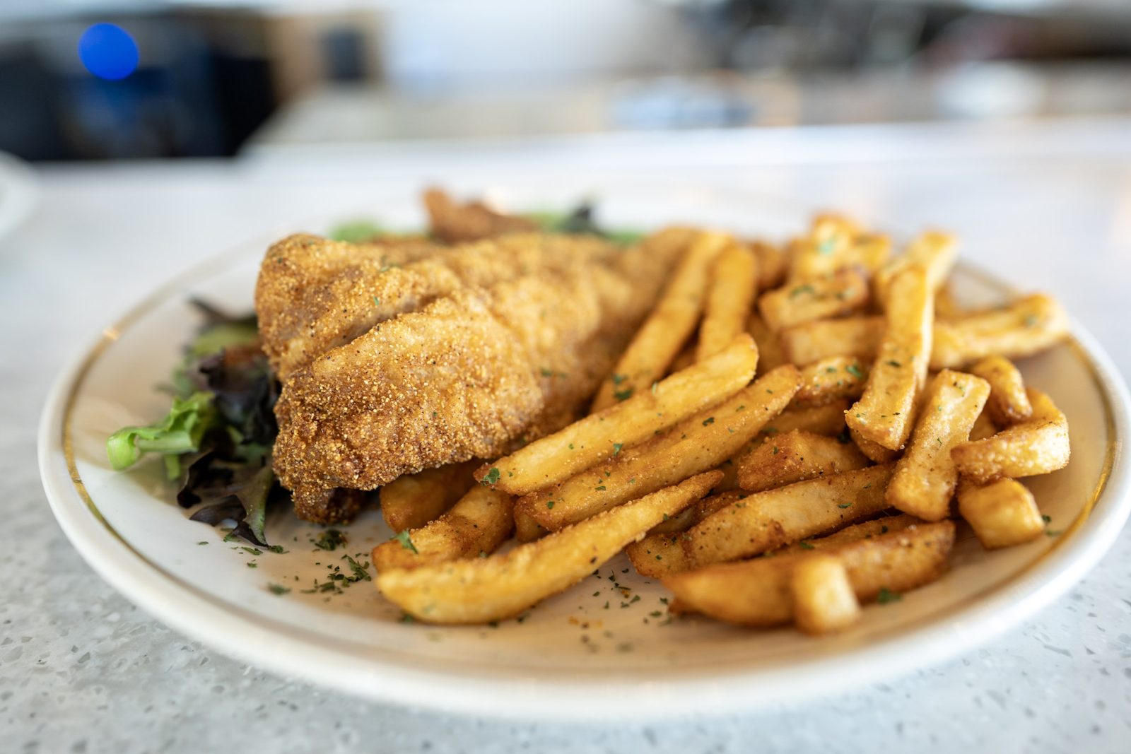 The Cajun Fried Fish and Shrimp Basket: cornmeal-crusted fried fish and shrimp over mixed greens with seasoned fries
